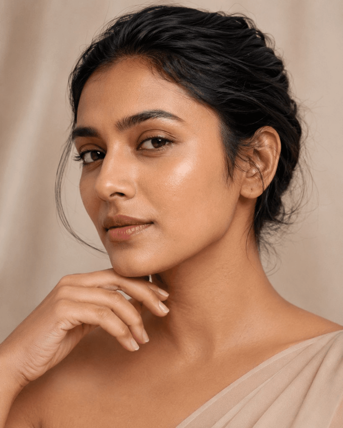 An Indian woman with soft, hydrated skin in warm neutral light